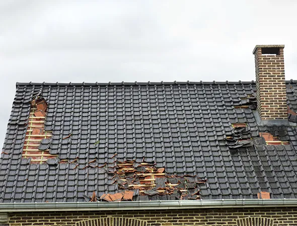 A house with visible roof damage, highlighting the importance of roof insurance for potential repairs and protection.
